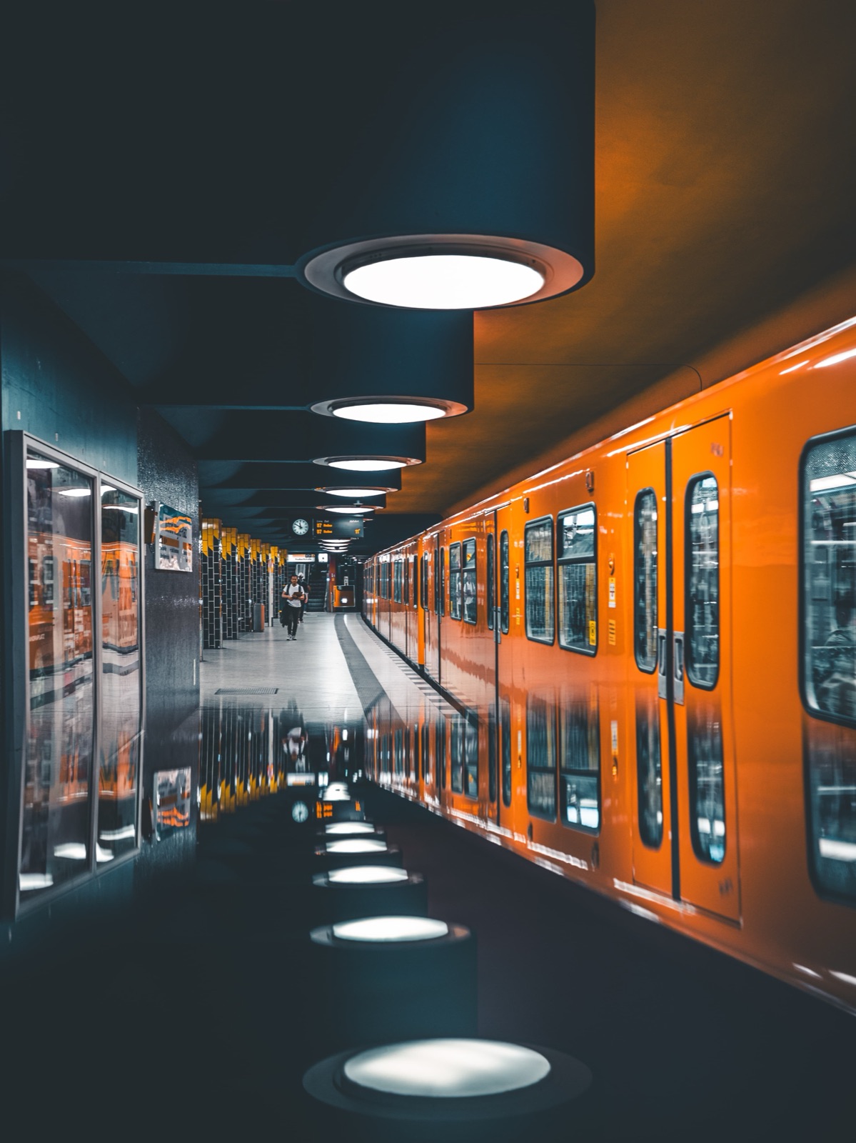 Berliner U-Bahnhof mit oranger Bahn und Spiegelung
