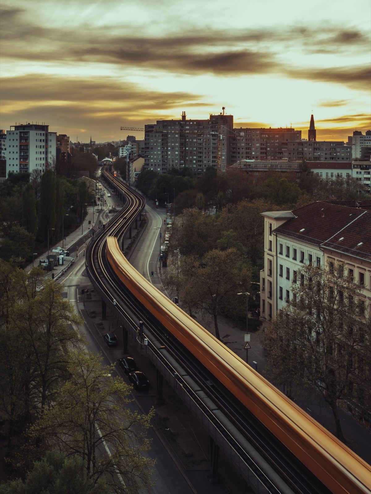 Berliner Hochbahn zur goldenen Stunde, Lichtspur der U-Bahn über der Stadt